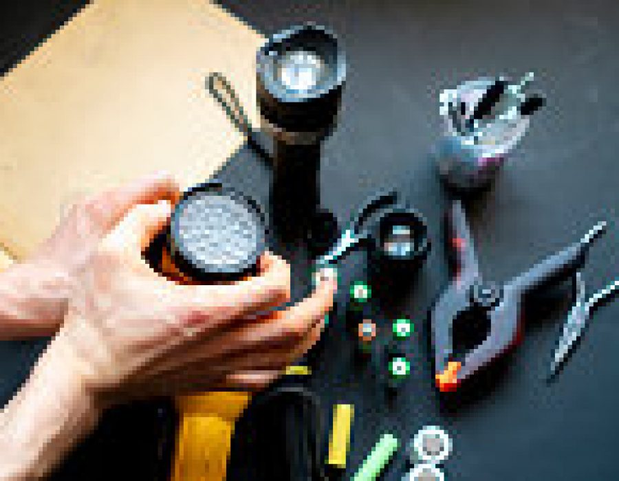 persons hands hold a flashlight in a workshop